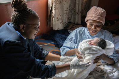 Mookho Lefikanyana, a nurse at PIH-supported Tlhanyaku Health Center, assists ‘Makefuoe Kabai and her daughter Kefuoe Kabai.