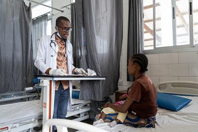 James G. Fah, acting officer in charge at PIH-supported Pleebo Health Center, during an appointment with patient Marthaline G. Davis and her baby, Lisa Willions, in Maryland County, Liberia.