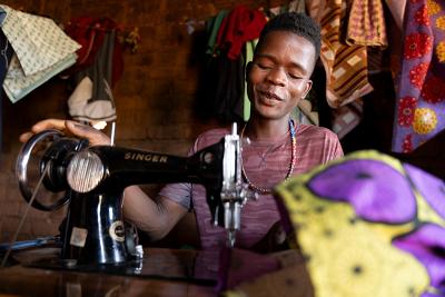Patrick Francis, a 19-year-old ASPIRE project participant trained in tailoring, uses his sewing skills.