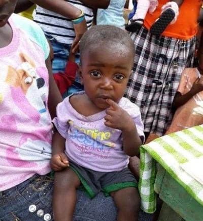 Mother and child sit at malnutrition mobile clinic in Haiti