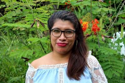 Woman wearing glasses standing in front of trees