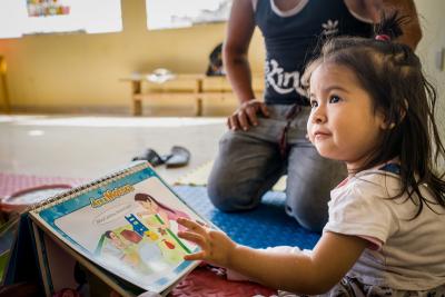 A child plays with an interactive picture book.