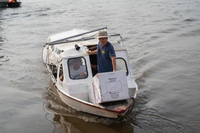 A man standing in a small boat.