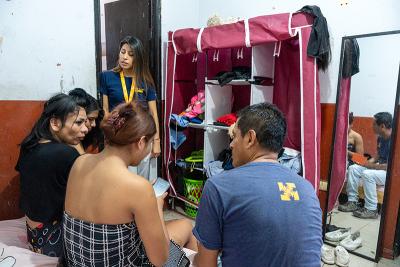 Carla Rodríguez, JunTrans project coordinator (seen standing) and technical assistant Walter Rojas (far right) speak with N., Daniela, and Paloma in their home at El Muro. 