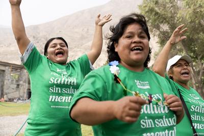 Three community health workers celebrate outside.