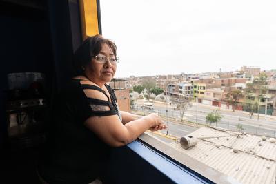Woman looking out a window over a city view.