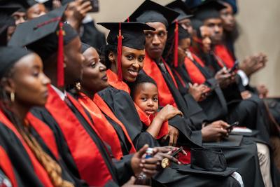 Nina Sandra Natasha Ngowi, UGHE Master of Science in Global Health Delivery alumna, during the graduation ceremony with her daughter, Isheja Vania Rubagumya.