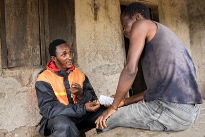 Sahr Moses Jawara (left), mental health and psychosocial assistant supervisor, meets with Aiah Messah in Sierra Leone.