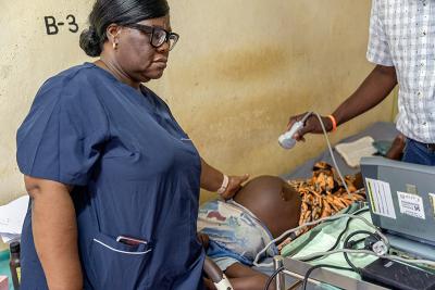 Sister Patricia Efe Azikiwe (left), KGH’s reproductive, maternal, newborn, child, and adolescent clinical program manager, and OBGYN Dr. Eseoghene Dase (right) examine Sia.