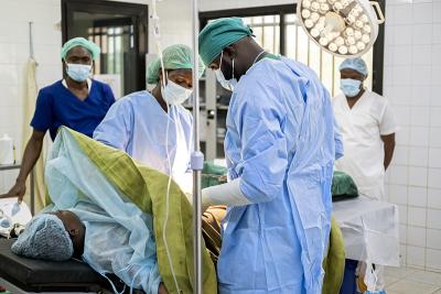Doctors perform a C-section on Sia while nurses, midwives, and other staff provide ongoing support.
