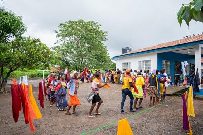 Fifty women sing and dance together joyfully.