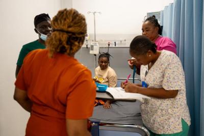 Healthcare worker holding a newborn in an operating room.