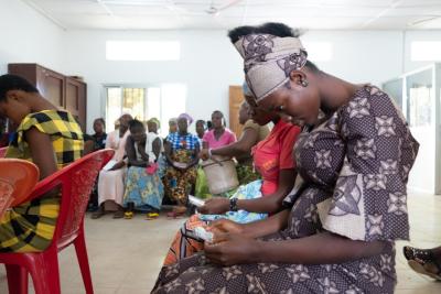 Abi Dauda looks at the personal ID card she received at Wellbody Clinic, used to securely access her electronic medical records.