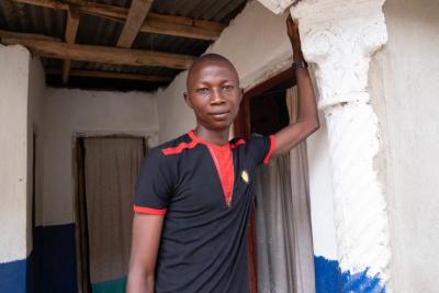 Student in Sierra Leone leaning against a wall.