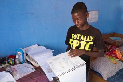 Young boy in Sierra Leone reading a book.