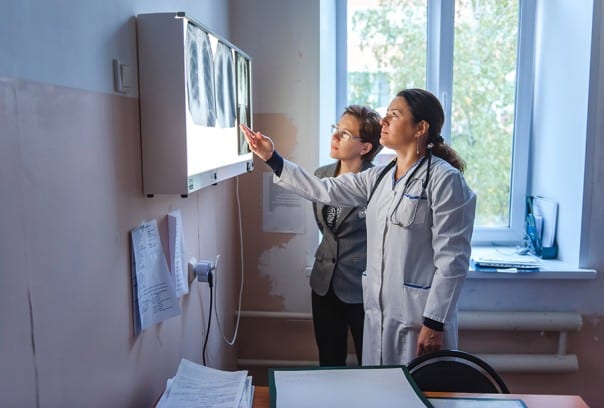 Clinical lead Irina Pershina and PIH manager Alexandra Solovyova look at x-rays of tuberculosis-infected lungs in Russia.