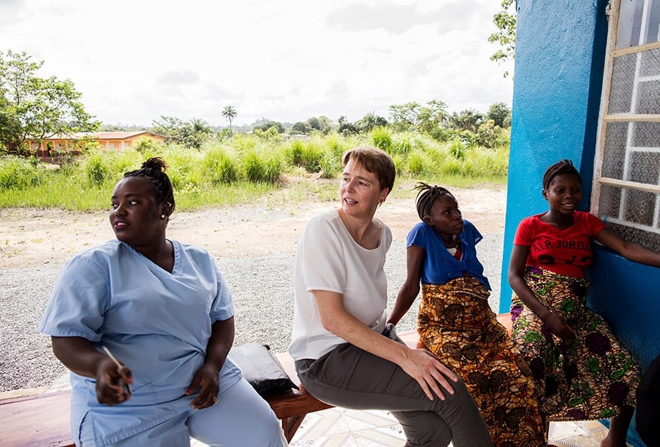 PIH Co-founder Ophelia Dahl (center) and Nurse Ndamba Mansaray (left) visit with Isah Kaimoko (second from right) and Kumba Finohtwo (right), two pregnant women staying at the Wellbody Birth Waiting Home in Kono, Sierra Leone.