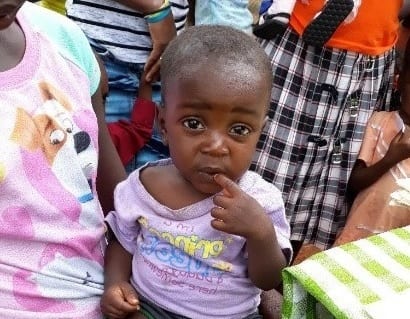 Marcellus Adnelson, 1 year old, sits with his mother after 8 weeks of treatment at a mobile clinic
