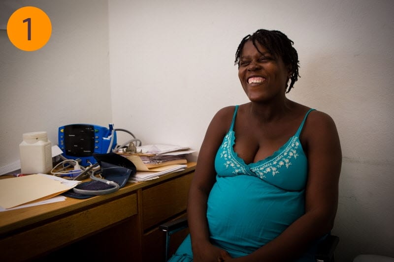 An expecting mother sits smiling in a room at University Hospital