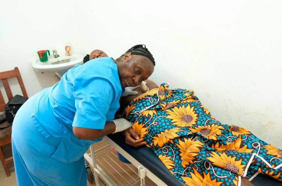 A traditional birth attendant at Wellbody Clinic in Kono, checks on a pregnant patient