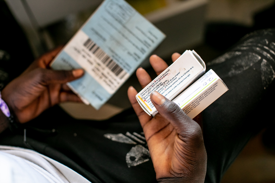 Kerefasi Wiliyamu holds his medications in his lap
