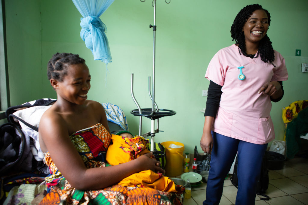 A mother sits holding her child at Neno District Hospital, Malawi. Support from the Slaight Family Foundation will allow PIH to continue to improve health care for women and girls in Malawi. 