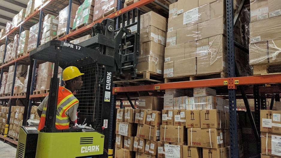 A warehouse worker moves stock using a fork lift in Port-au-Prince, Haiti, as part of the PIH supply chain team.