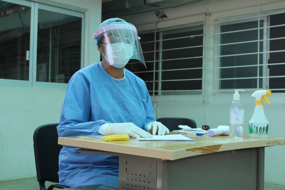 A nurse wearing PPE sits in a triage area as part of PIH's response to COVID-19 in Mexico
