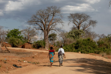 APZU Community Health Worker Grace Mgaiwa (right) walks with Eliza Kazembe (left) during a maternal health home visit near PIH-supported Lisungwi Community Hospital in Neno District, Malawi.