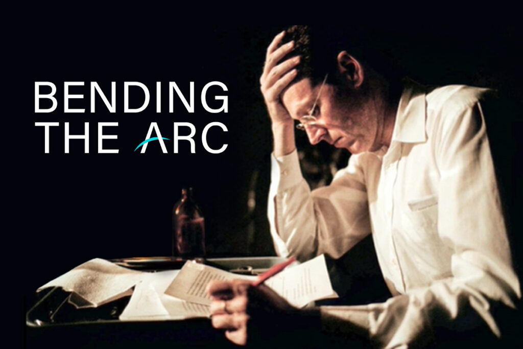 Bending the Arc will be available on Netflix on Oct 22. Dr. Paul Farmer sits at a desk writing.