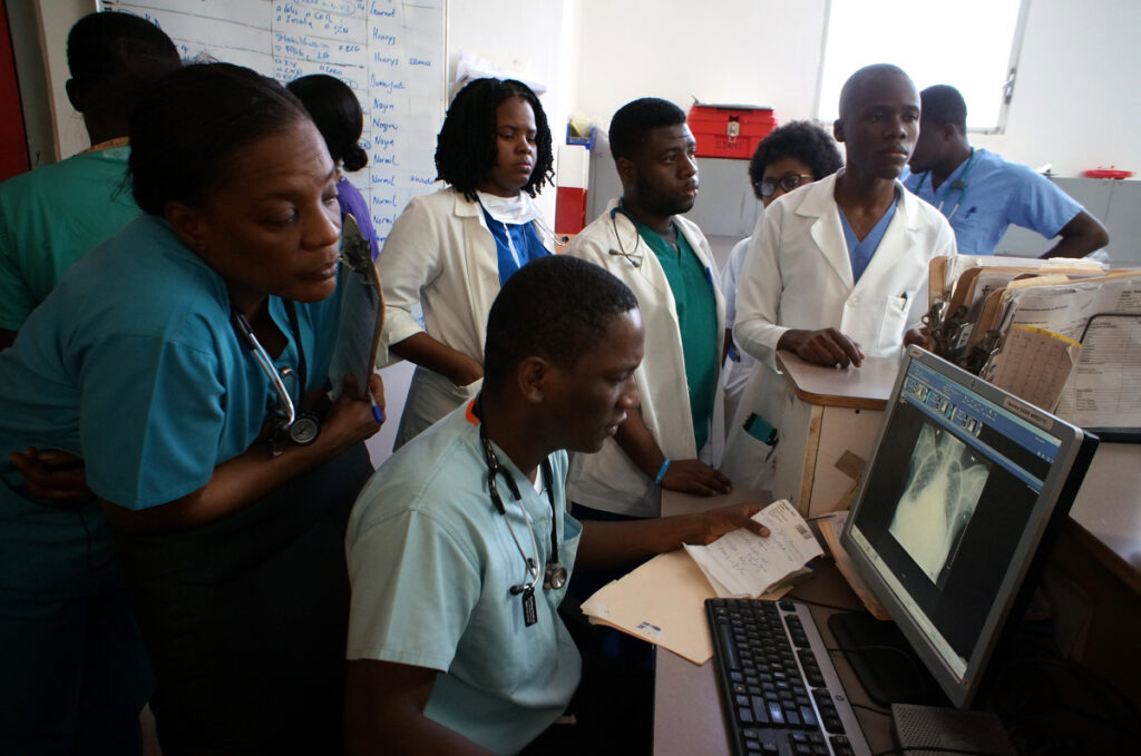 As part of University Hospital of Mirebalais’ Residency Program Dr. Eliezer Dade sits at the computer reviewing a patient's chest x-ray in the emergency department.