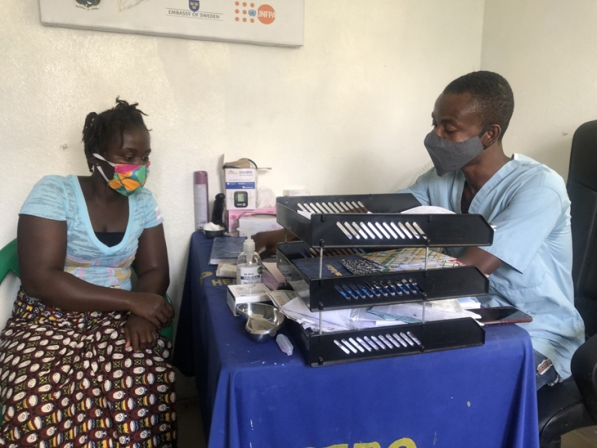 Ayumi Williams (left), a mother of two, receiving counselling from Luke Kruger Jr. (right) prior to taking her injection at the youth-friendly center at Pleebo Health Center in Maryland County, Liberia. (Photo by Marian Roberts/PIH)